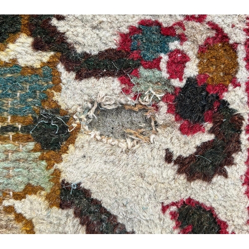 733 - A Caucasian rug having a repeating floral motifs on a cream ground within a red and floral border, 1... 