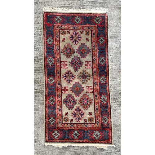 734 - A Persian rug, with repeating geometric motifs on a red ground within a blue and yellow geometric bo... 