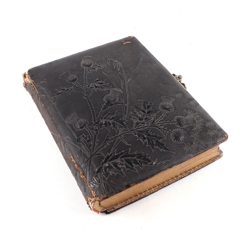 743 - An Edwardian leather photograph album, the cover with embossed thistle decoration, containing carte ... 