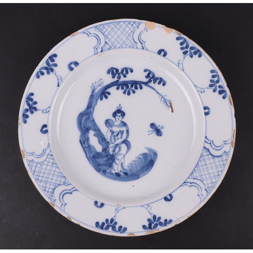 766 - An 18th century Bristol Delft plate decorated with a Chinese woman holding a fan under a tree, 23cms... 