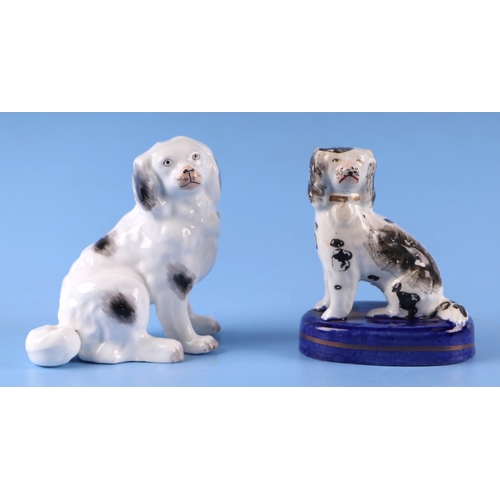 769 - A 19th century Staffordshire figure of a dog, 10cms high; together with another similar on an oval b... 