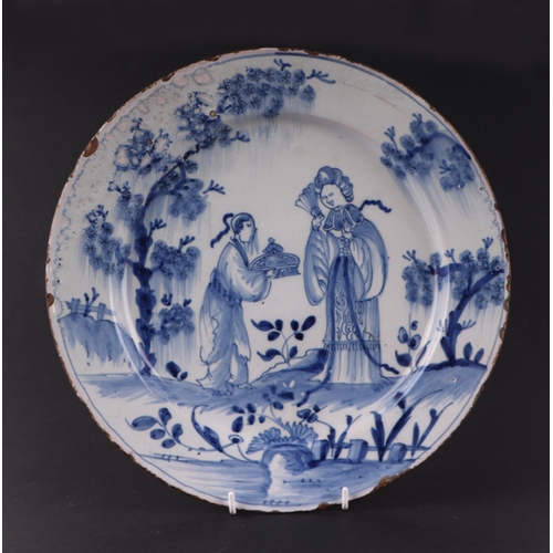 771 - An early 18th century English Delft shallow dish decorated with a chinoiserie scene depicting a lady... 