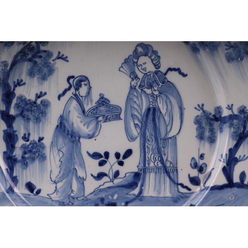 771 - An early 18th century English Delft shallow dish decorated with a chinoiserie scene depicting a lady... 