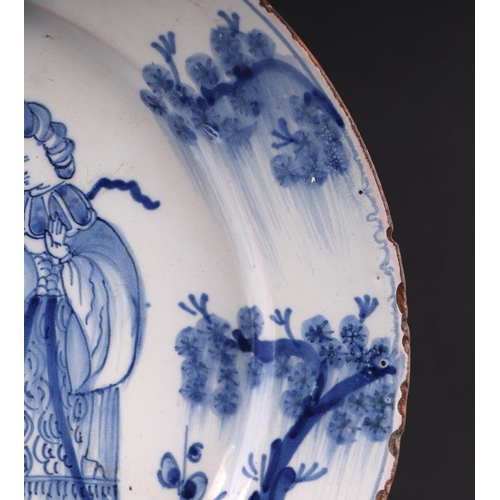 771 - An early 18th century English Delft shallow dish decorated with a chinoiserie scene depicting a lady... 