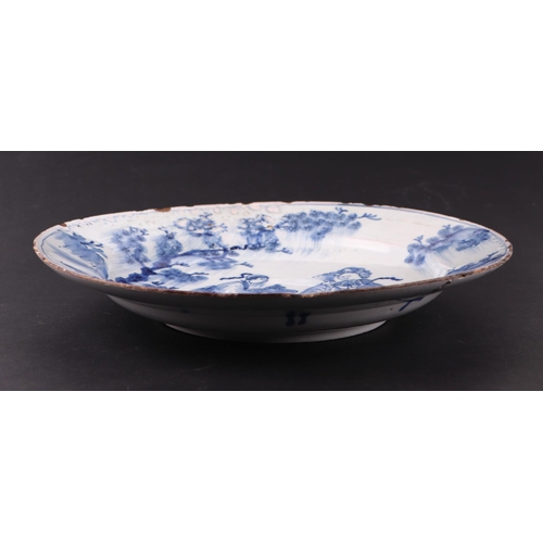 771 - An early 18th century English Delft shallow dish decorated with a chinoiserie scene depicting a lady... 