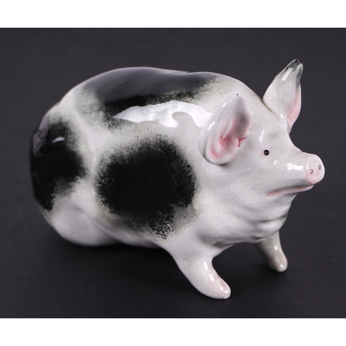 780 - A Wemyss pottery pig seated on its haunches painted with black sponged markings and pink ears, impre... 