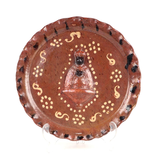 82 - A slipware dish with pie crust rim, the central relief depicting Moorish type religious figures, 27c... 