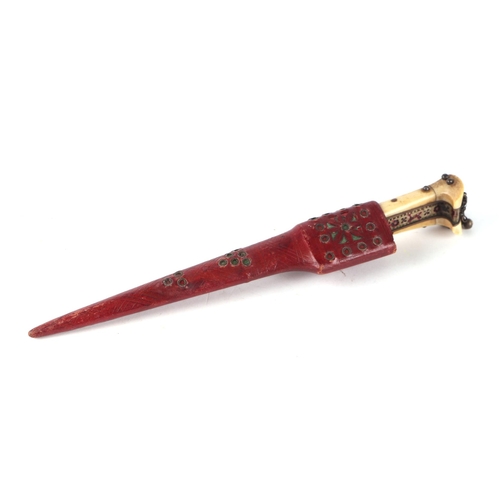 841 - A North West Frontier Khyber dagger in an ornate red leather sheath with tapering steel blade and bo... 