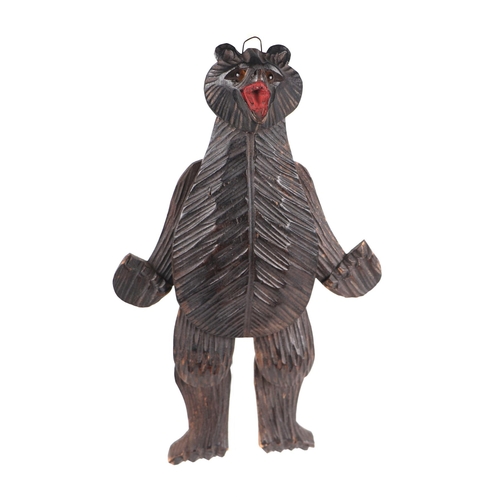 956 - A Black Forest carved wooden articulated dancing bear, 25cms high.