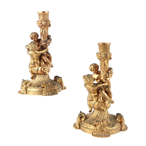 963 - A pair of Regency rococo style gilt bronze candlesticks after Juste-Aurèle Meissonier, 22cms high (2... 