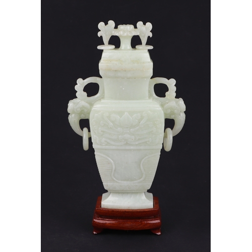 1984A - A Chinese pale jade vase and cover of flattened baluster form with flower finial on hardwood stand, ... 