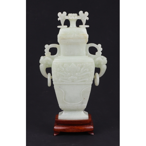 1984A - A Chinese pale jade vase and cover of flattened baluster form with flower finial on hardwood stand, ... 