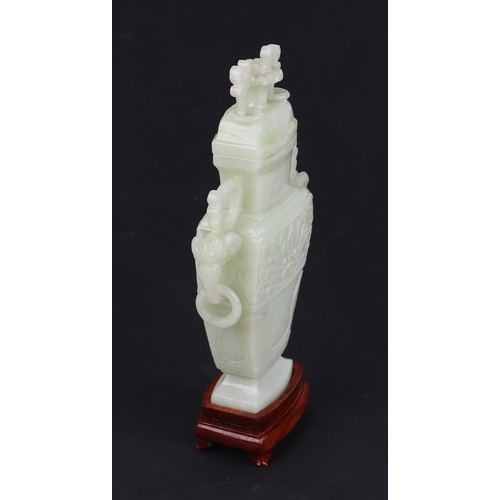 1984A - A Chinese pale jade vase and cover of flattened baluster form with flower finial on hardwood stand, ... 