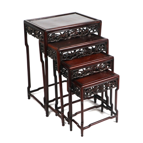 667 - A nest of four Chinese rosewood tables with ornate carved and pierced freeze, largest 52cm wide.