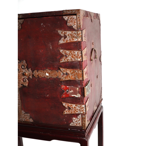 631 - A Chinese leather covered trunk with copper reinforced strap work, the twin doors opening to reveal ... 