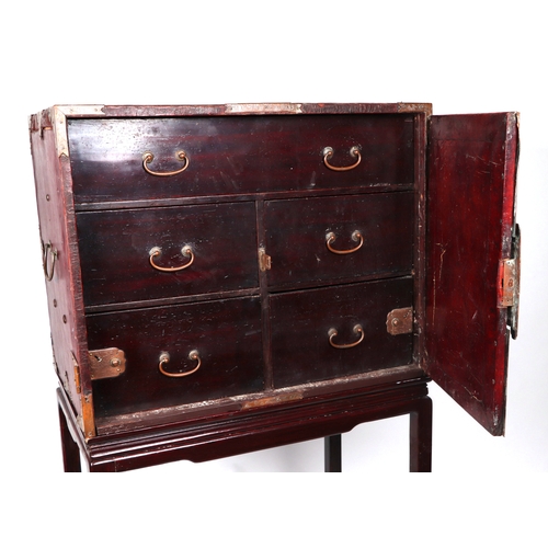 631 - A Chinese leather covered trunk with copper reinforced strap work, the twin doors opening to reveal ... 