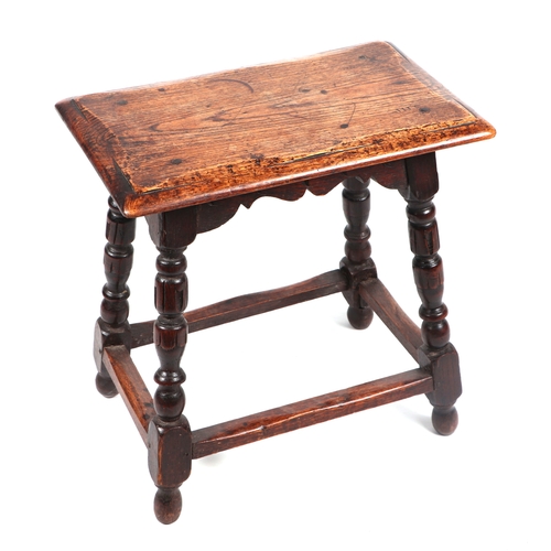 2071 - A 17th century style oak joint stool on turned supports joined by stretchers, 46cms wide.