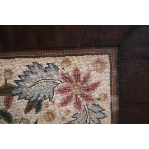 1367 - A needlework tapestry panel depicting flowers and foliage, 49 by 57cms, in a rosewood frame.