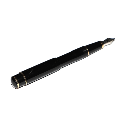 1033 - A black lacquer and gilt metal fountain pen with iridium point nib, 13cms long.