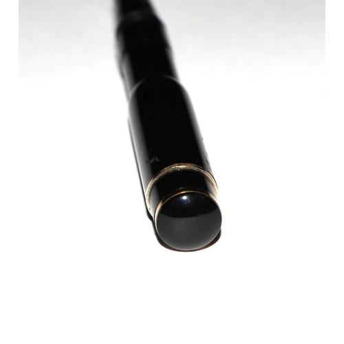 1033 - A black lacquer and gilt metal fountain pen with iridium point nib, 13cms long.