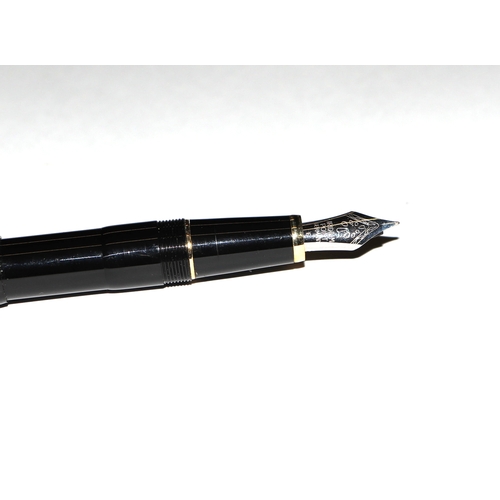 1033 - A black lacquer and gilt metal fountain pen with iridium point nib, 13cms long.