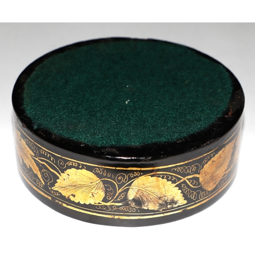 962 - A 19th century Regency papier-mâché wine coaster with gilt leaf decoration, 13cms diameter.