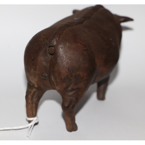 1040 - A cast iron mechanical clockwork table bell in the form of a pig with glass eyes, 14cm long