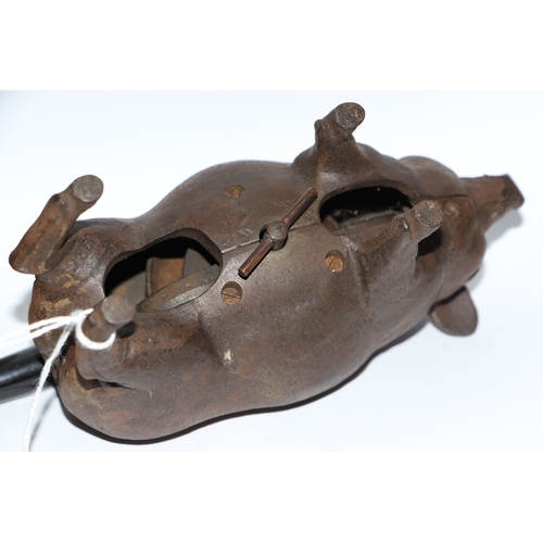 1040 - A cast iron mechanical clockwork table bell in the form of a pig with glass eyes, 14cm long