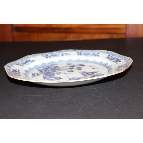 635 - A pair of 19th century Chinese blue & white plates of octagonal form decorated with a river landscap... 