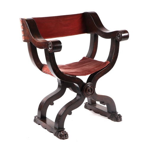 1028 - A Gothic style carved wood folding 'X' frame chair with carved lion paw feet.