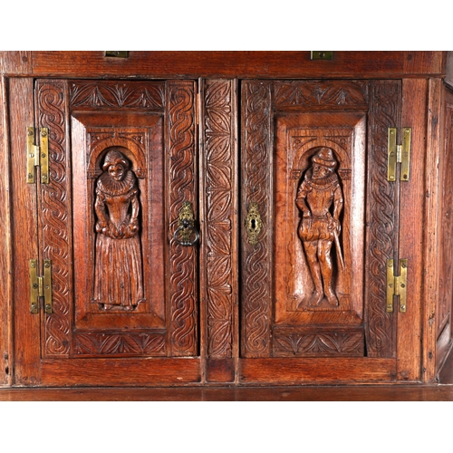 1035 - A 19th century carved oak cupboard, the superstructure with canted corners, the fall-flap frieze cup... 