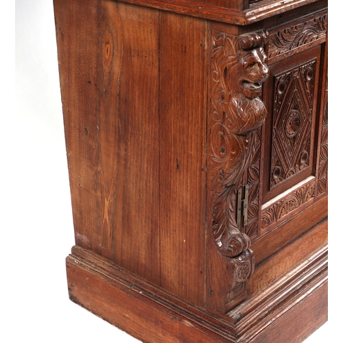 1035 - A 19th century carved oak cupboard, the superstructure with canted corners, the fall-flap frieze cup... 