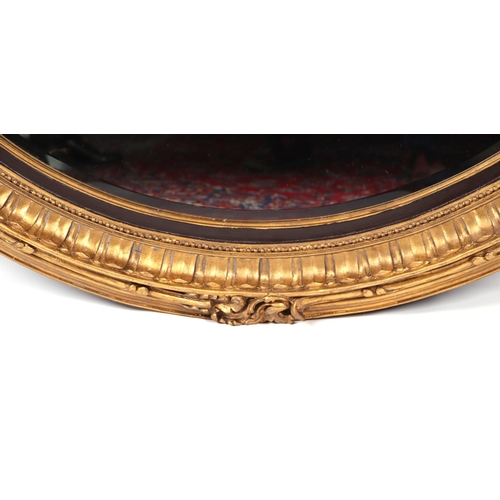 1036 - A large oval giltwood and gesso wall mirror, overall 106 by 153cms.