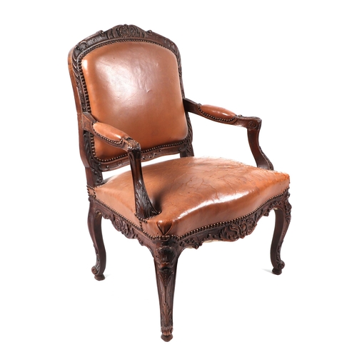 1073 - A French walnut open armchair with leather upholstered seat and back.