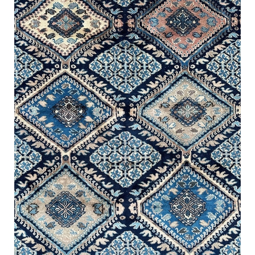 164 - A large Persian rug decorated a geometric design. 203 by 295cm