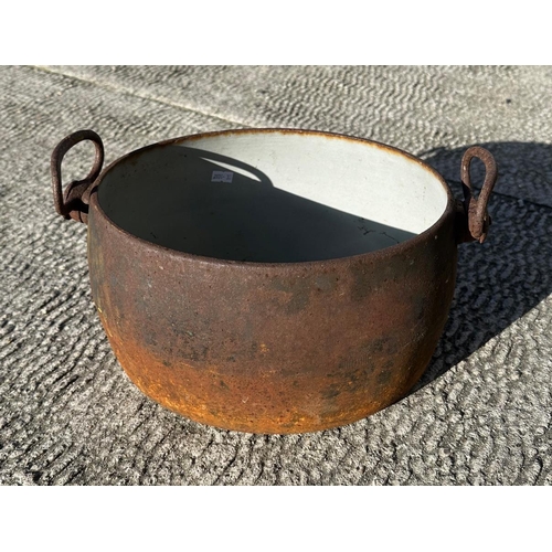 4 - A cast iron and enamel two-handled two-gallon cooking pot by Izons & Co., 34cms wide.