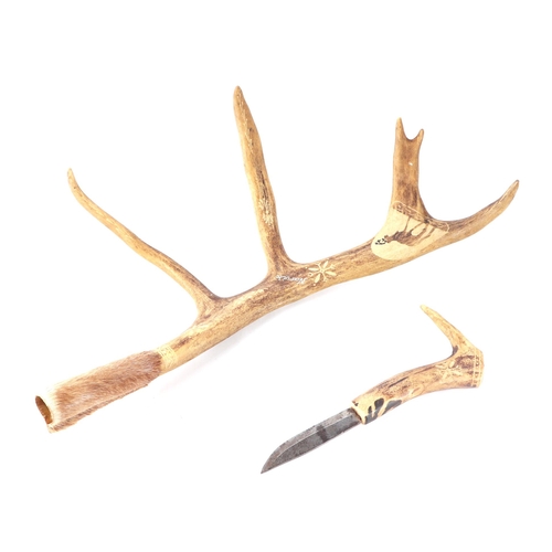 466 - A reindeer antler with folk art decoration inset with a short dagger, 50cms long.