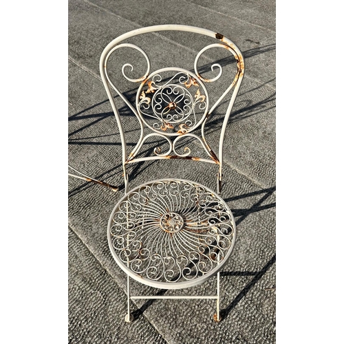 6 - A distressed painted metal garden patio set comprising circular table and two folding chairs (3).