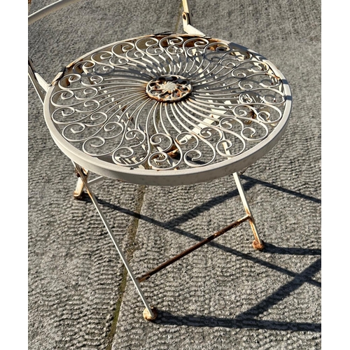 6 - A distressed painted metal garden patio set comprising circular table and two folding chairs (3).