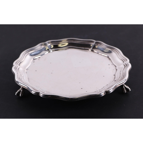 649 - A George V silver waiter with wavy rim on ball & claw feet, Sheffield 1919, 15cms diameter, 220g.