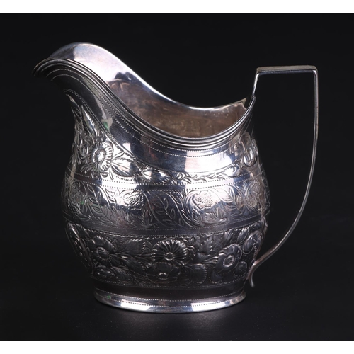 690 - A George III silver cream jug ornately decorated with flowers and shells, London 1804, 9.5cms high, ... 