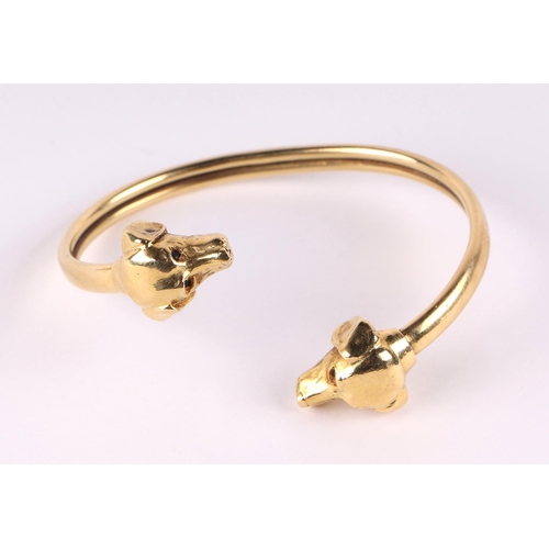 786 - An 18ct gold bangle with dog head terminals and sapphire eyes, 30g.