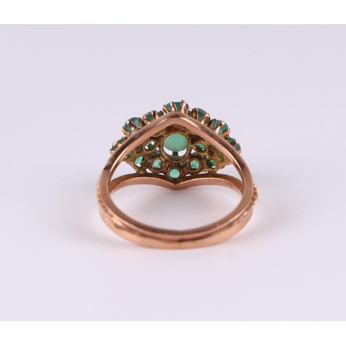 812 - A yellow metal dress ring set with green stones, approx UK size L, 3.1g.