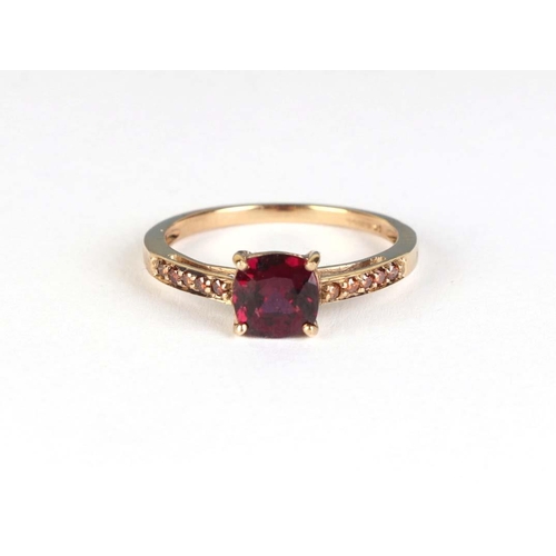 836 - A 9ct gold dress ring set with a central red stone and orange stone set shoulders, approx UK size S,... 