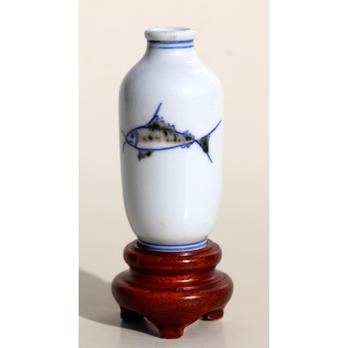 929 - A Chinese porcelain snuff bottle decorated with fish, on a hardwood stand, 7.5cms high.Condition Rep... 