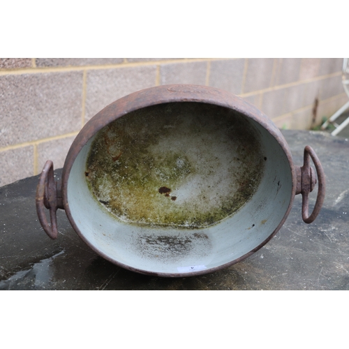 4 - A cast iron and enamel two-handled two-gallon cooking pot by Izons & Co., 34cms wide.