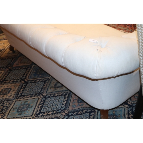 1043 - A Chesterfield cream upholstered three-seater  sofa on turned  front legs, approx 190cms wide.