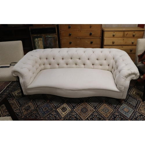 1043 - A Chesterfield cream upholstered three-seater  sofa on turned  front legs, approx 190cms wide.