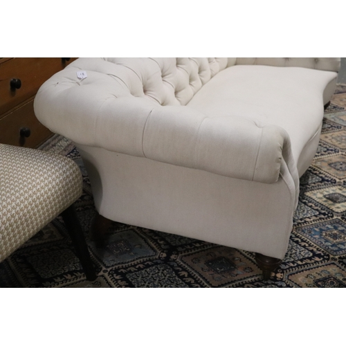 1043 - A Chesterfield cream upholstered three-seater  sofa on turned  front legs, approx 190cms wide.