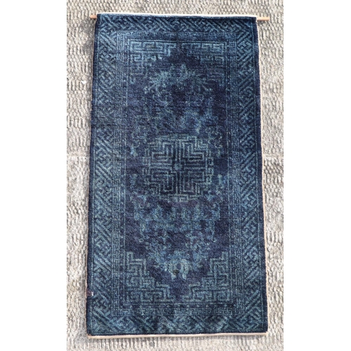 129 - A Chinese Ningxia rug, the central medallion within stylised borders on a blue ground, 105 by 56cms.